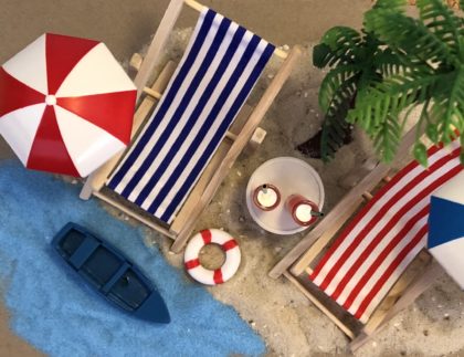 Strandmotiv mit Liegestühlen, Sonnenschirm und Getränken